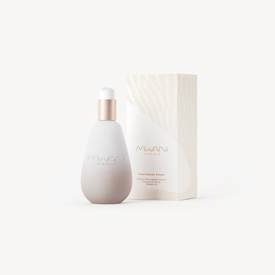 Golden bottle of Mwani Zanzibar’s Facial Cleanser & Mask, next to exterior packaging.