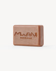 Bar of a sepia colored soap with Mwani Zanzibar logo engraved.