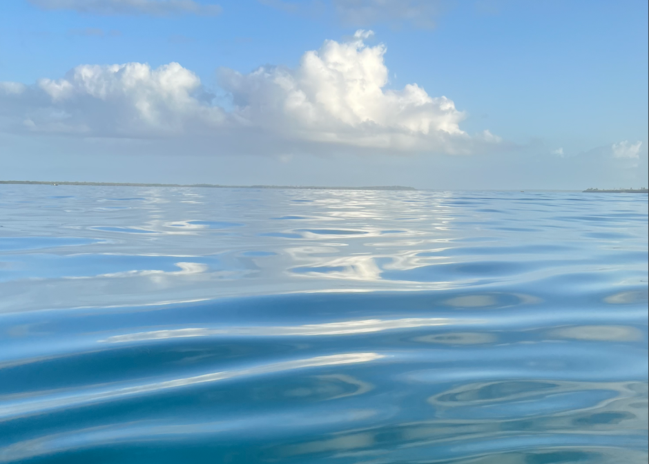 Reflection of clouds in the water, with blue sky in background.